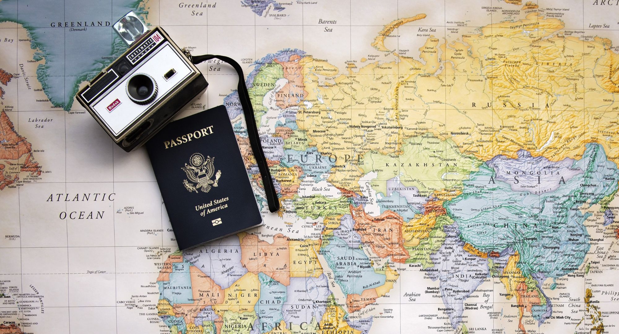 passport and vintage camera on a world map