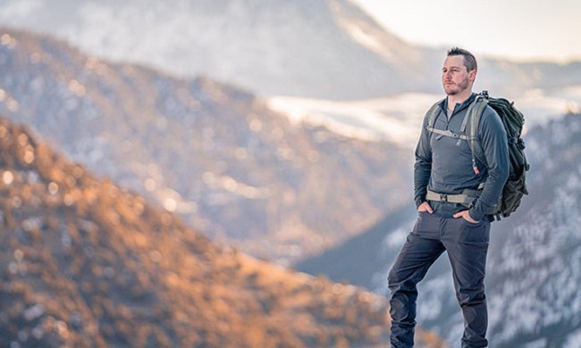 Man at the top of a mountain wearing a Merino wool sweater