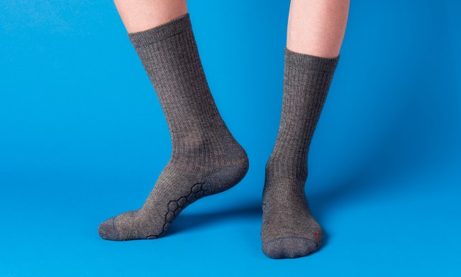 Feet wearing merino wool socks on a blue background.